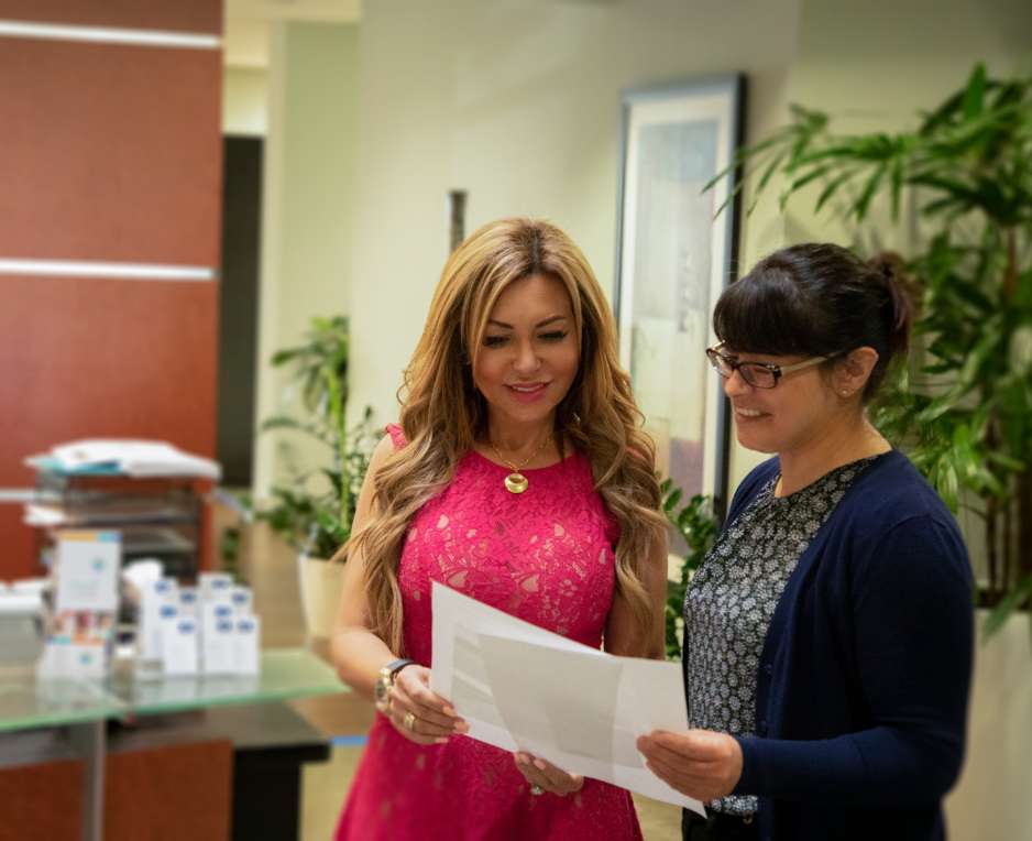 Personal injury lawyer Super Woman Super Lawyer Maryam Parman conferring with co-worker on documents