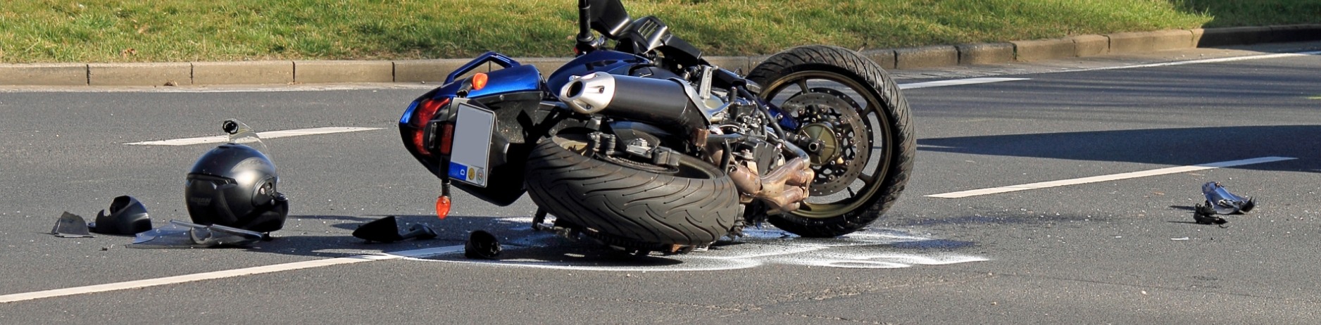 Motorcycle overturned in road with debris reinforcing the severity of motorcycle accident statistics