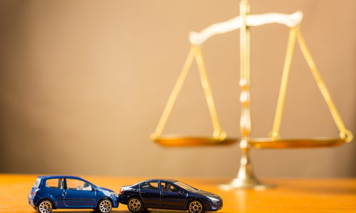 Toy cars in rear-end accident next to scale suggesting different types of personal injury cases