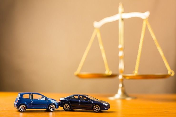 Toy cars in rear-end accident next to scale suggesting different types of personal injury cases