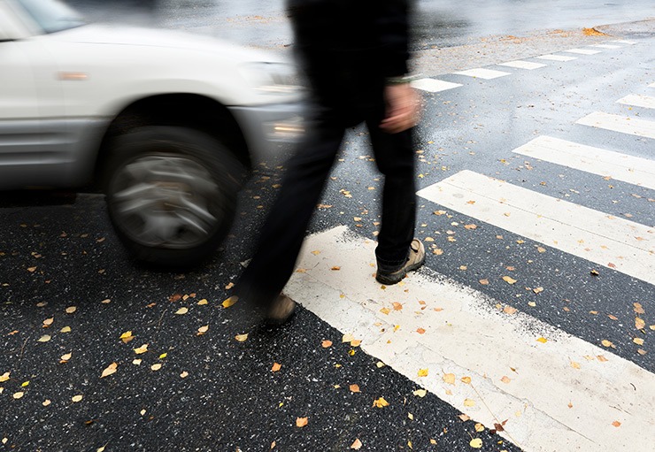 Pedestrian in crosswalk near car suggesting the need for a Los Angeles pedestrian accident attorney